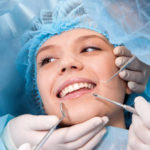 Young female dentist holding tooth model