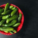 fresh-organic-cucumbers-in-red-basket-on-white-wooden-table-with-green-and-red-and-chili-peppers-fennel-salt-black-peppercorns-garlic-pea-close-up-healthy-concept-top-view-flat-lay-scaled.jpg