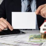 businessman-holding-empty-card-miniature-house_23-2148793802