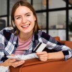 portrait-young-woman-sitting-sofa-with-phone_23-2148316734
